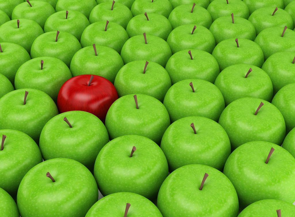 Red apple selected on the background of green apples