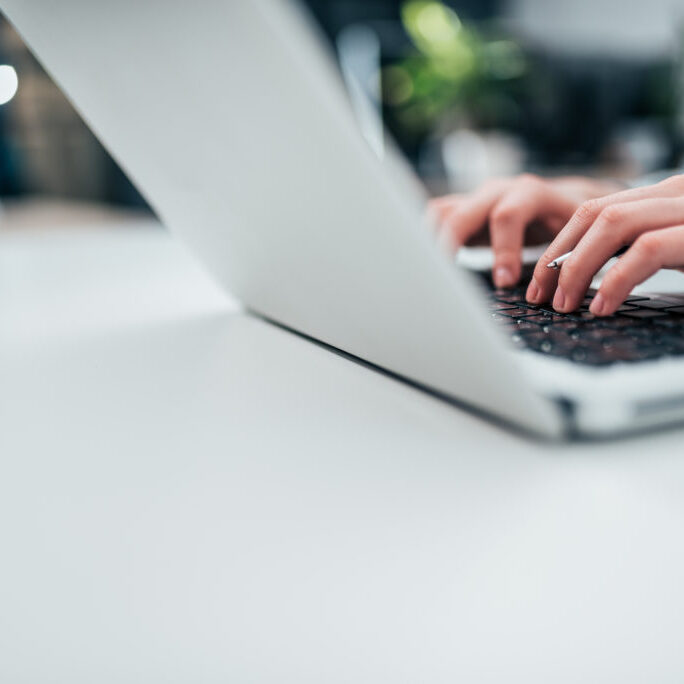 Female person typing on laptop. Close-up, copy space.