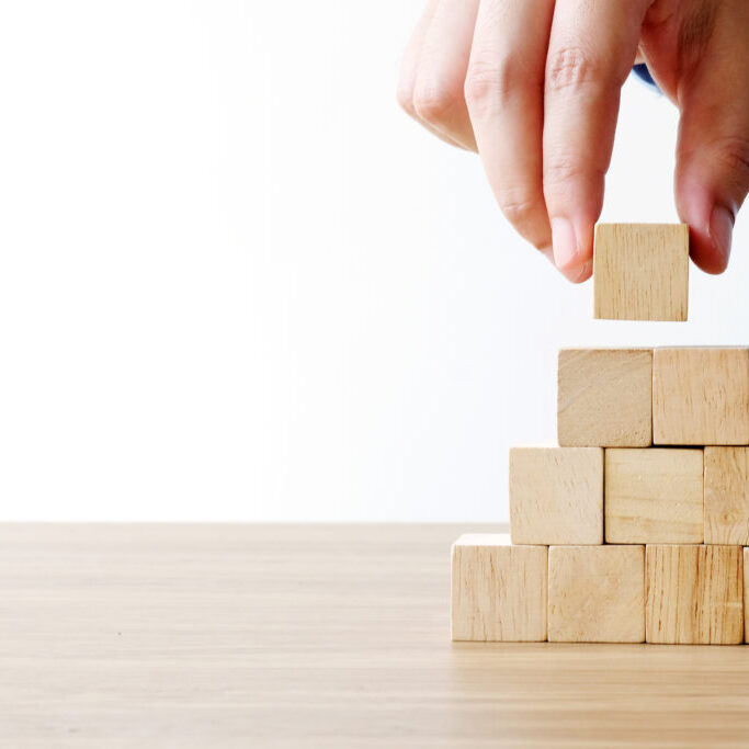 Hand holding blank wooden cubes, business concept background, mock up, template